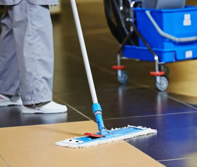 Profesional limpiando un piso comercial con sistema de microfibra